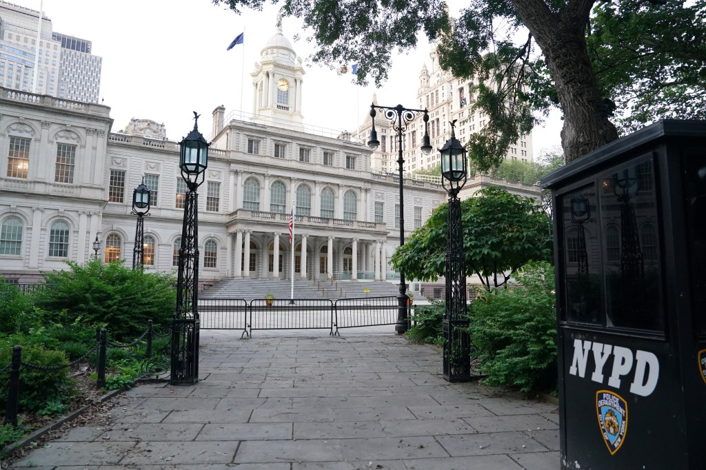 New York City Hall with an NYPD booth in the foreground.