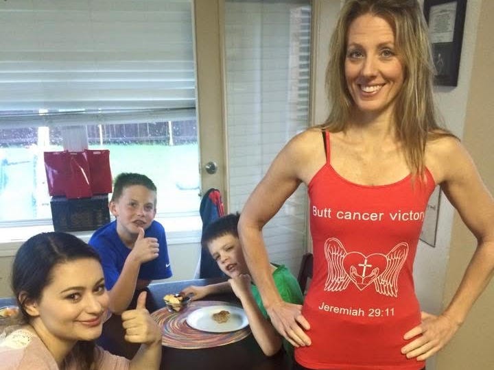 Tracy Robert standing in the kitchen with her family.