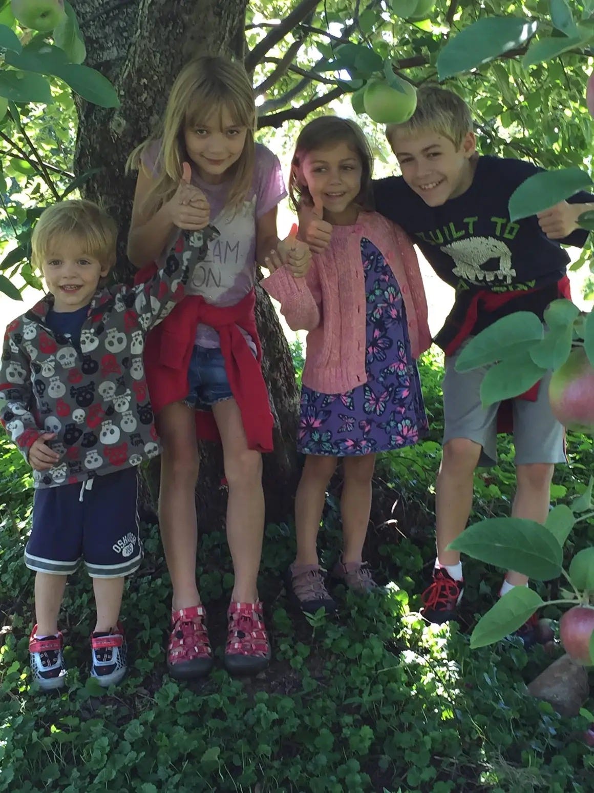 Nicole Johnson's four kids standing under a tree