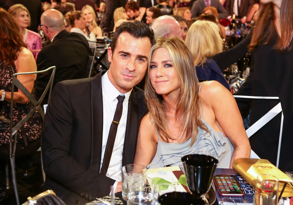 Jennifer Aniston in a grey dress, Justin Theroux in a black suit, white shirt and black tie.