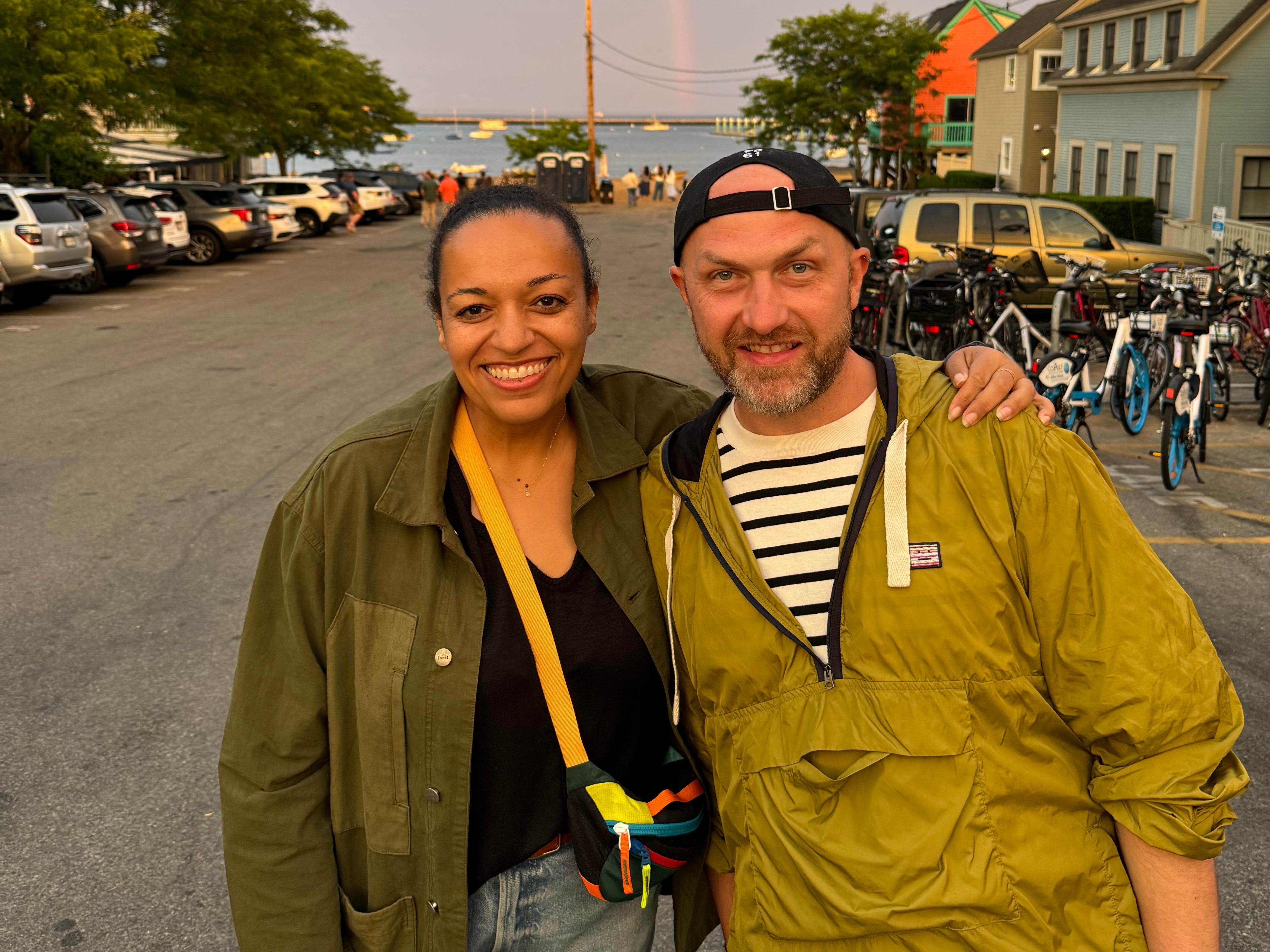 Wade TK and Selena Lounds stand in front of a rainbow.