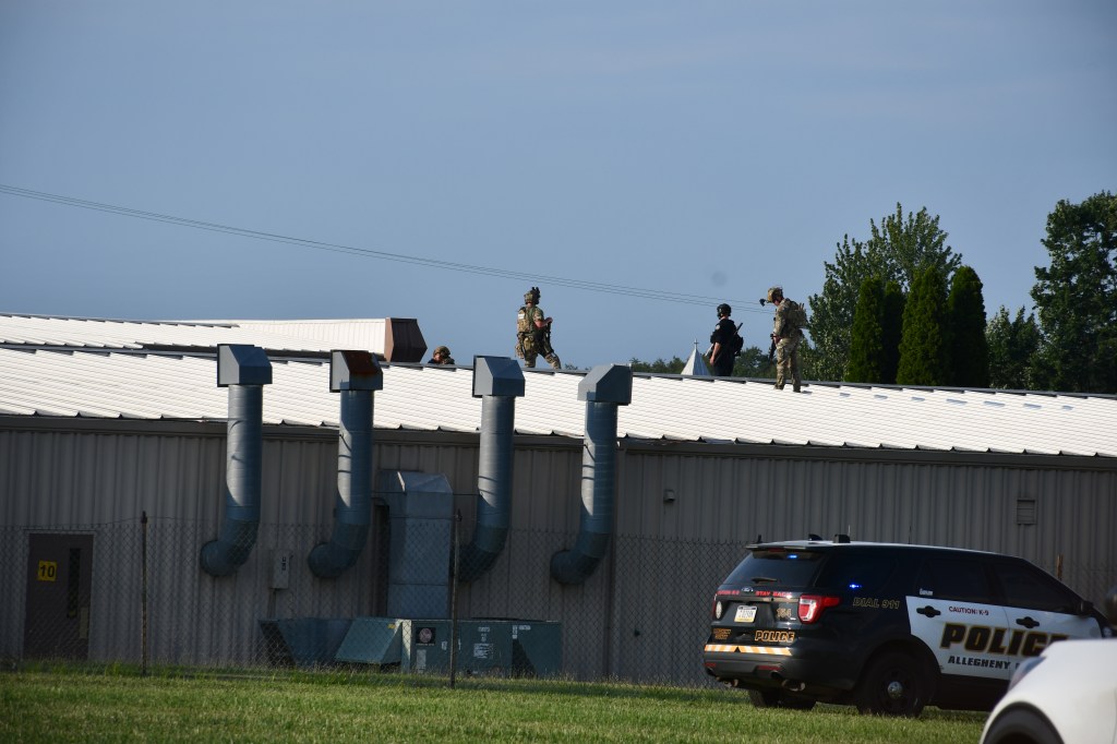 Police officers on a building rooftop after an assassination attempt.