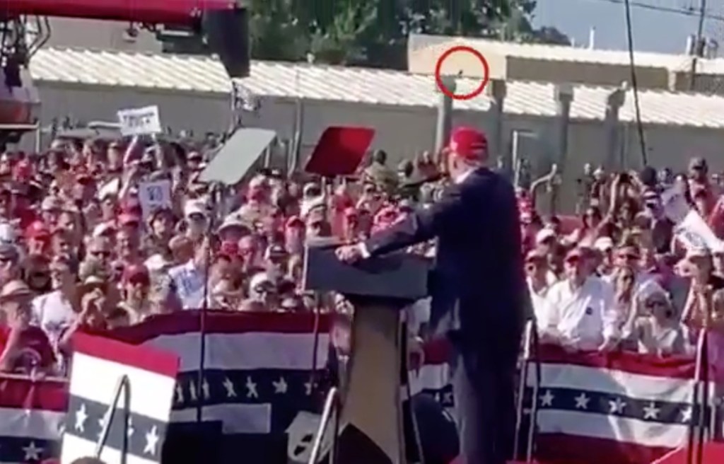 Video frame showing a person on a rooftop above a Trump rally moments before a shooting.