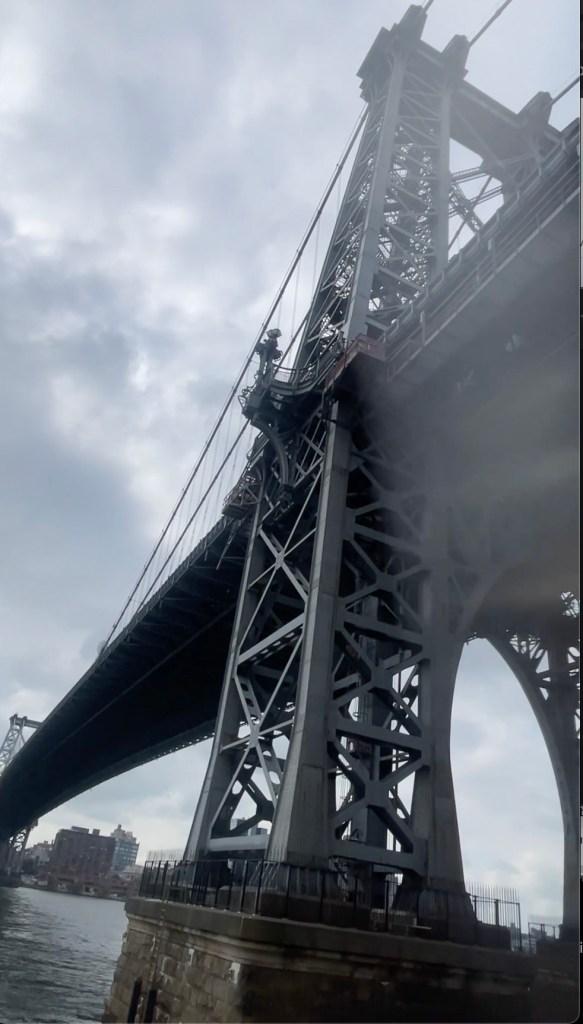 Stills from a video showing the Williamsburg Bridge and a body recovery operation in the water below.