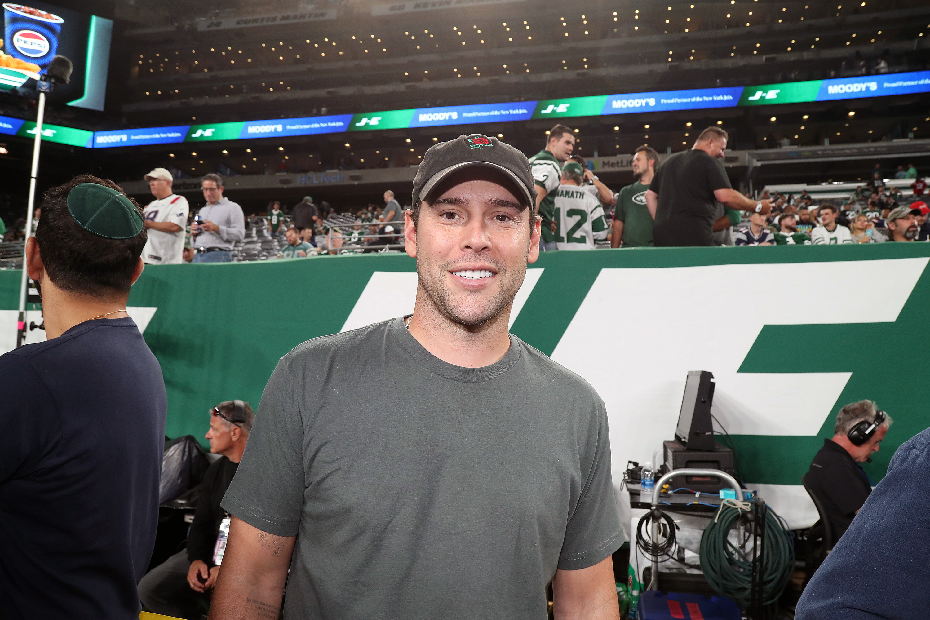 Scooter Braun smiles at an event in a ball cap. 