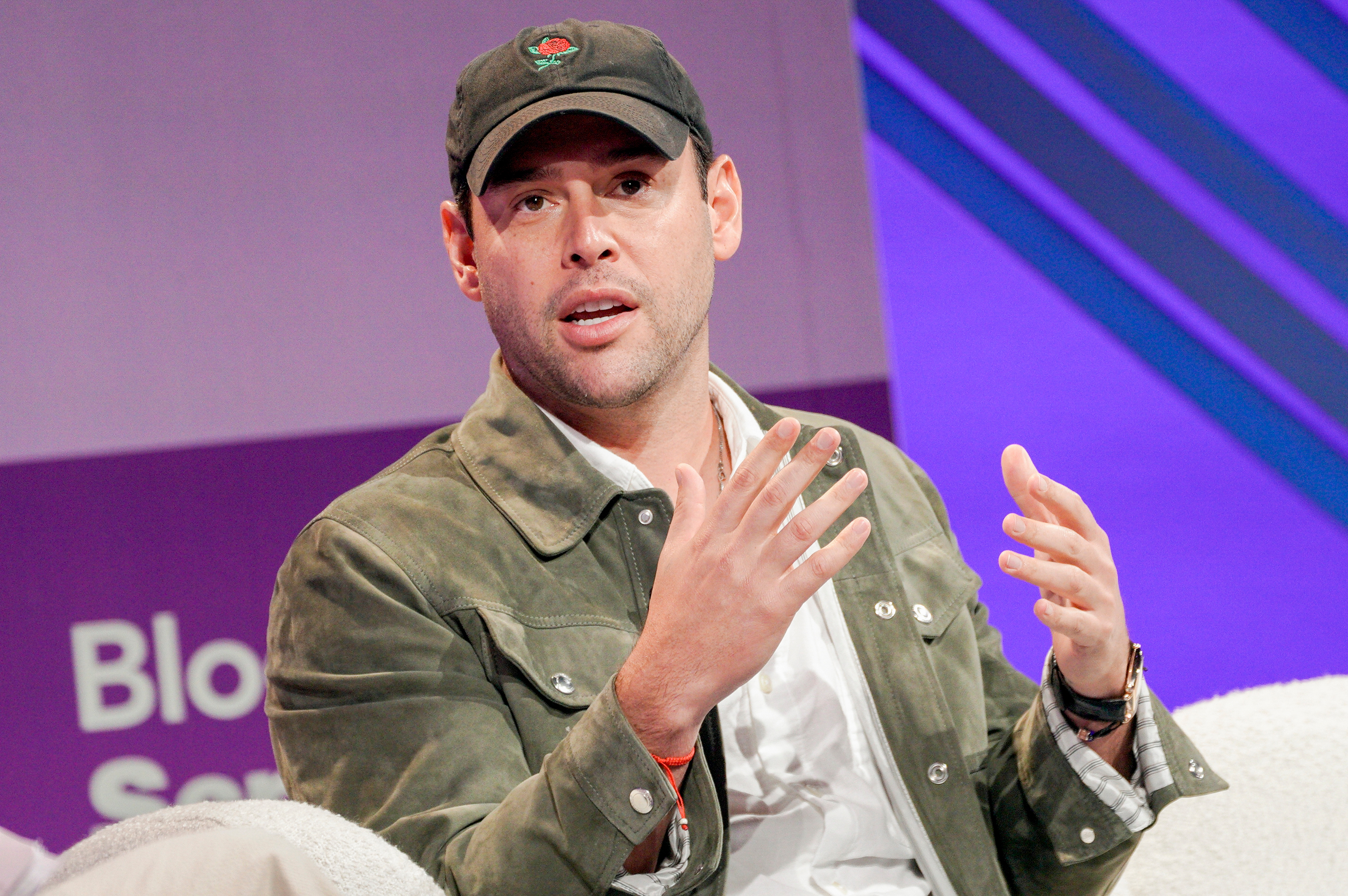 Scooter Braun sits on a couch while talking. 