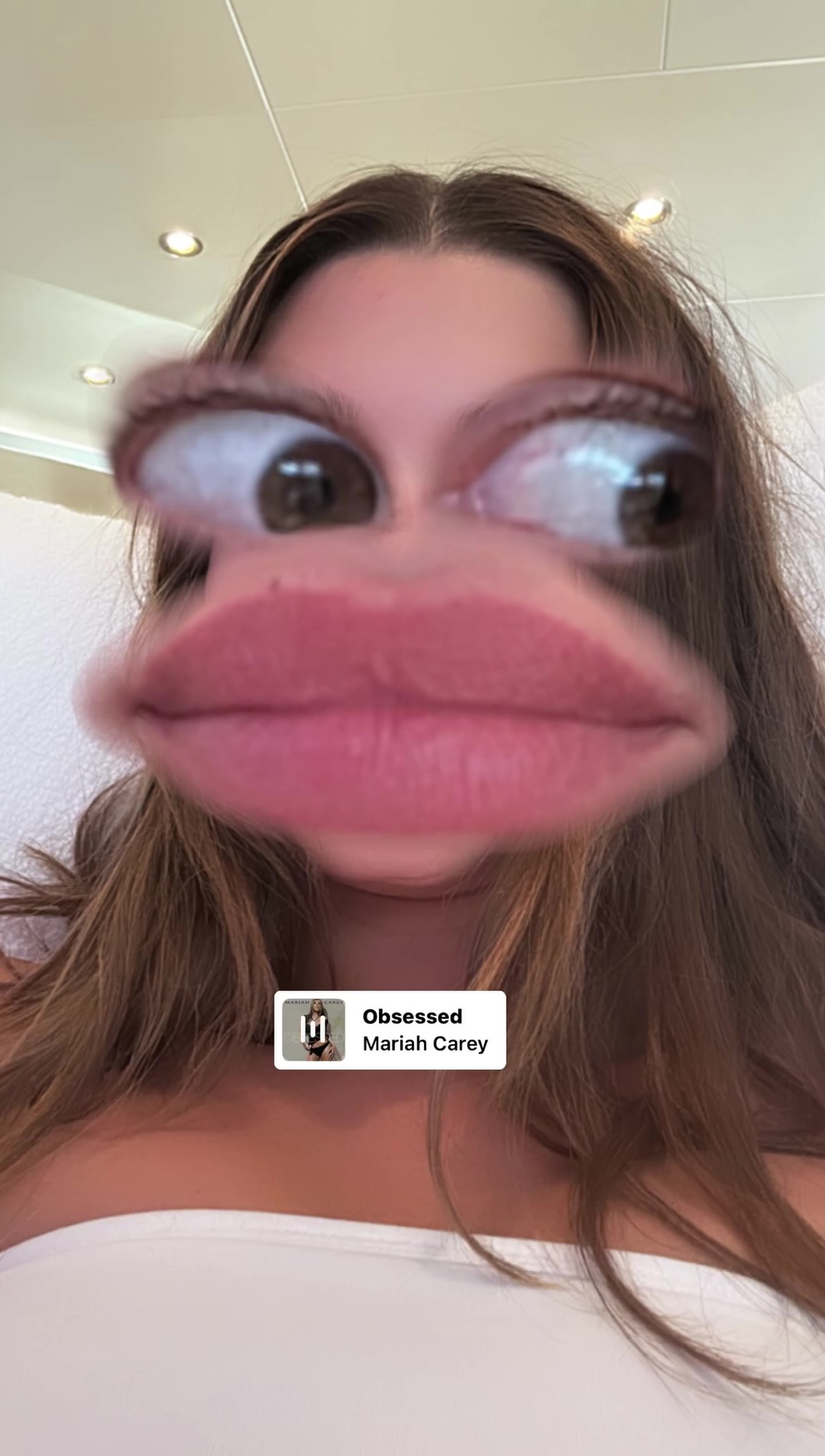Hailey Bieber in a selfie with large eyes and lips. 