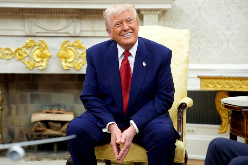 President Trump smiling during a meeting in the Oval Office.