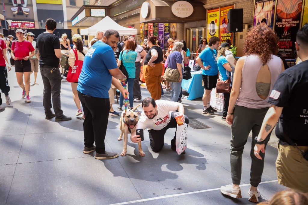 A man takes a photo of his dog at Broadway Barks.