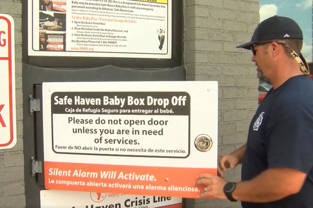 A man points to a safe haven baby box.