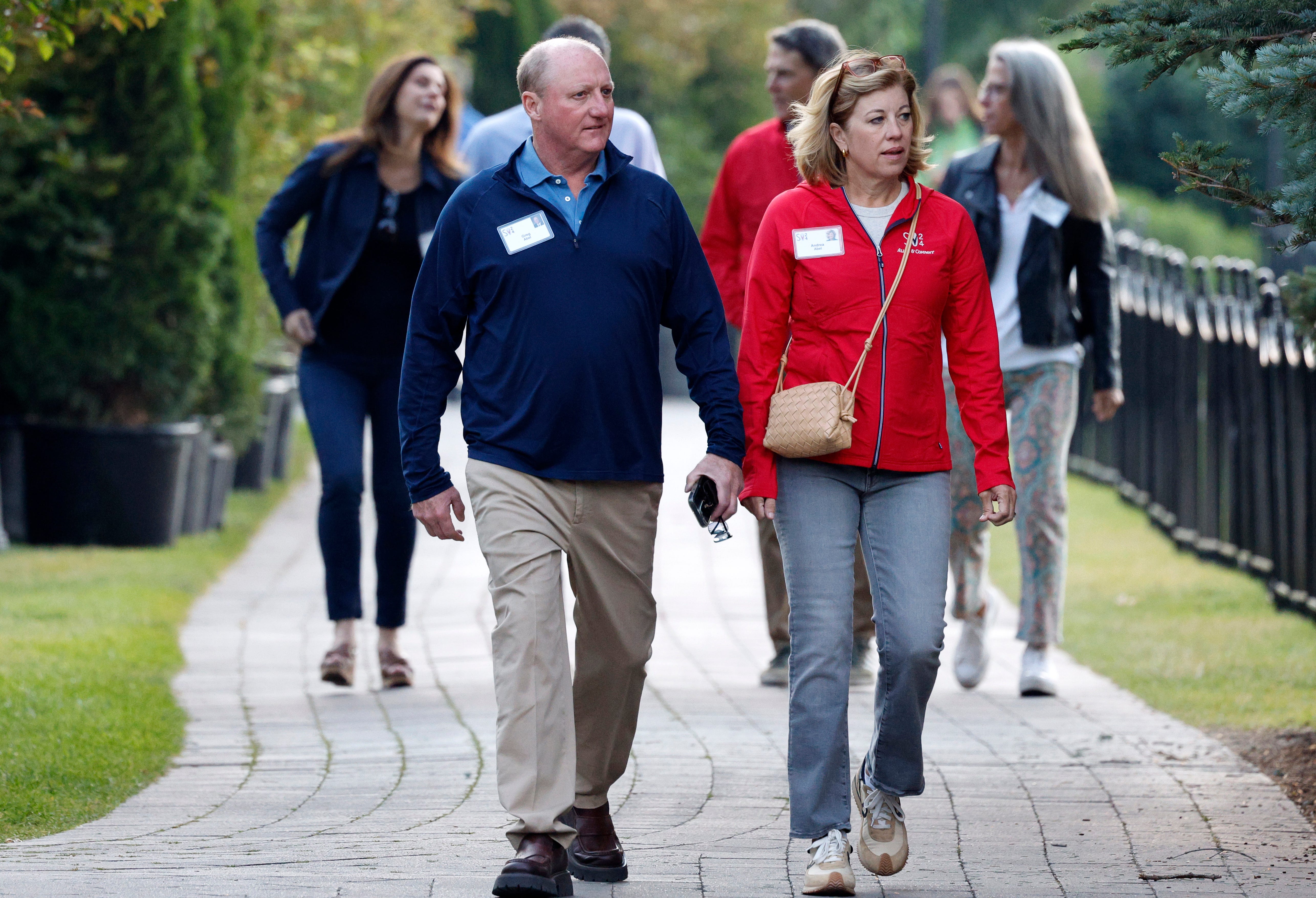 A man and woman walk alongside each down a path looking to the left
