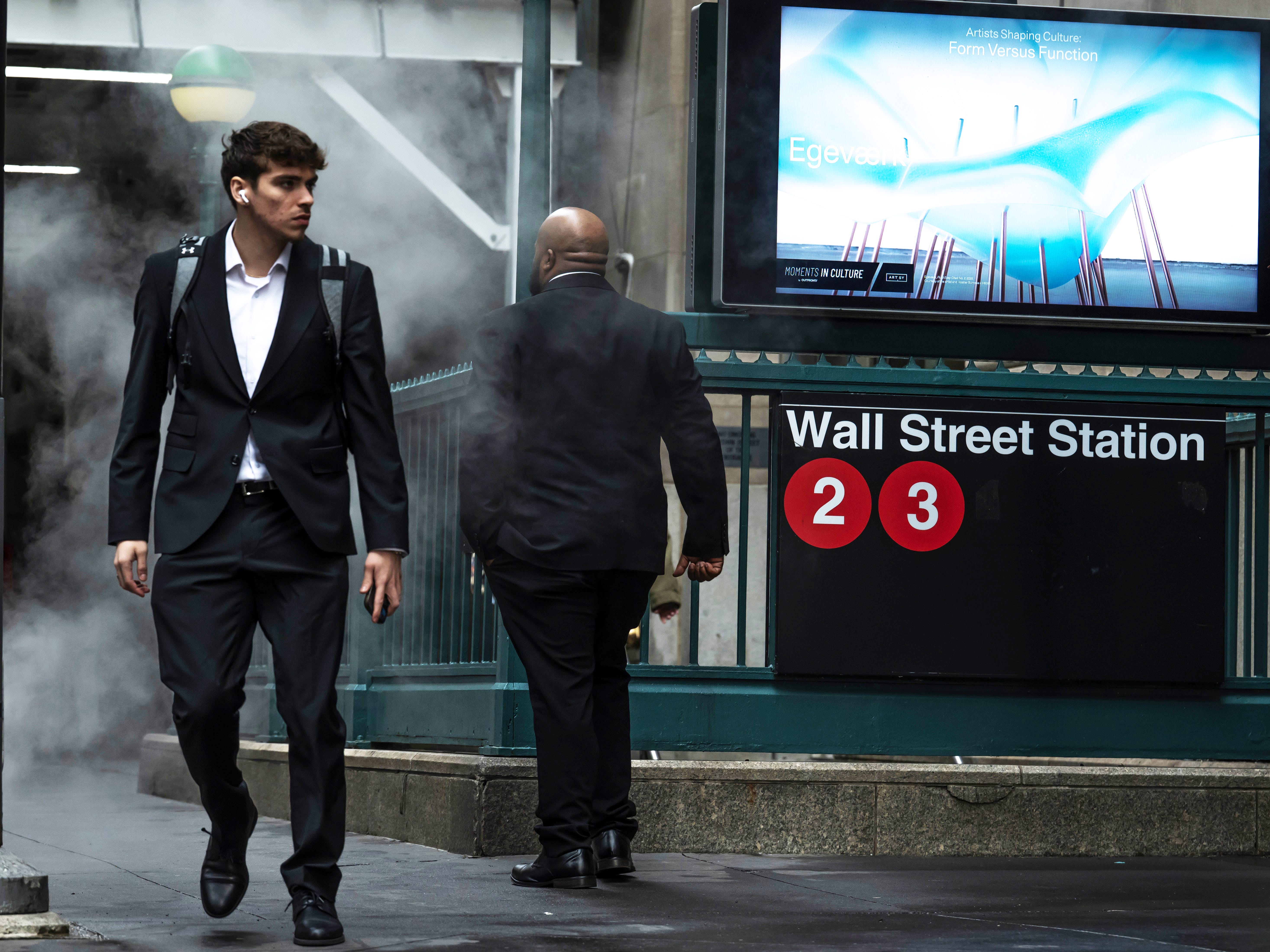 Men walk past the Wall Street subway station