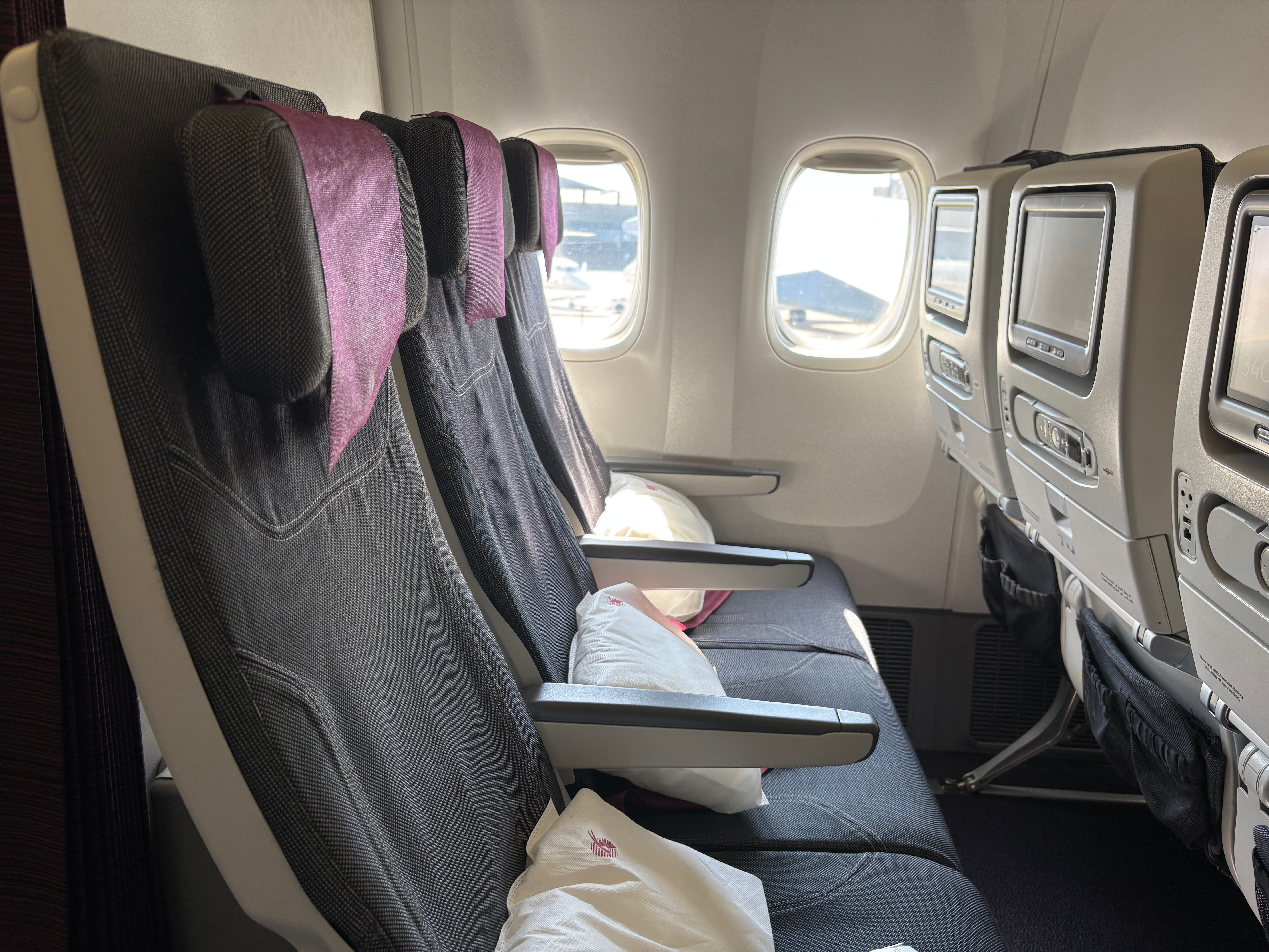 A row of economy seats on a Qatar Airways Boeing 777
