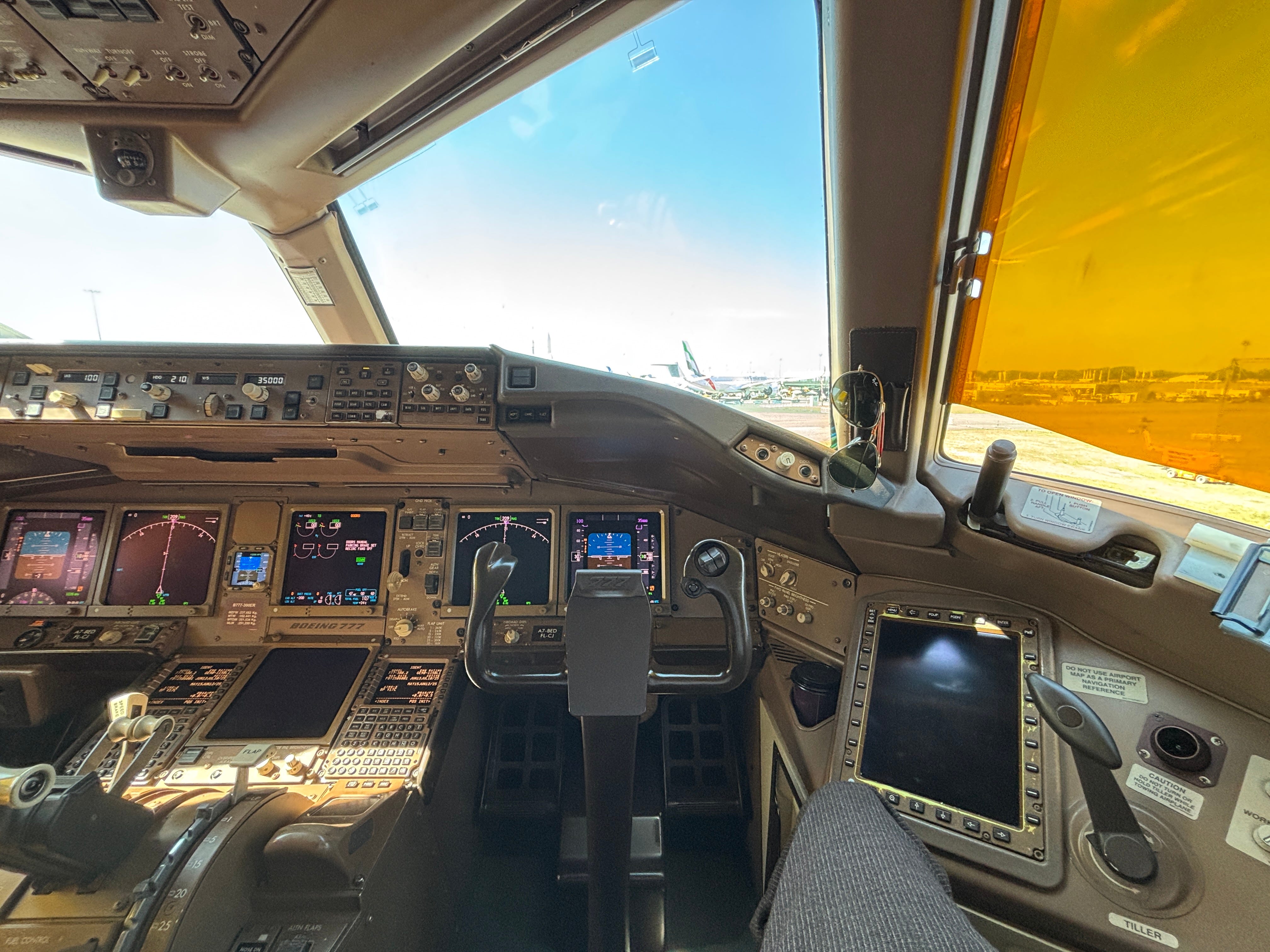 A first-person perspective view from the copilot's seat on a Qatar Airways Boeing 777
