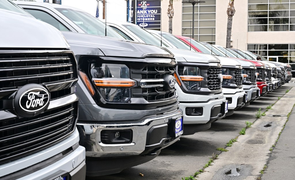 Row of Ford trucks at a dealership.