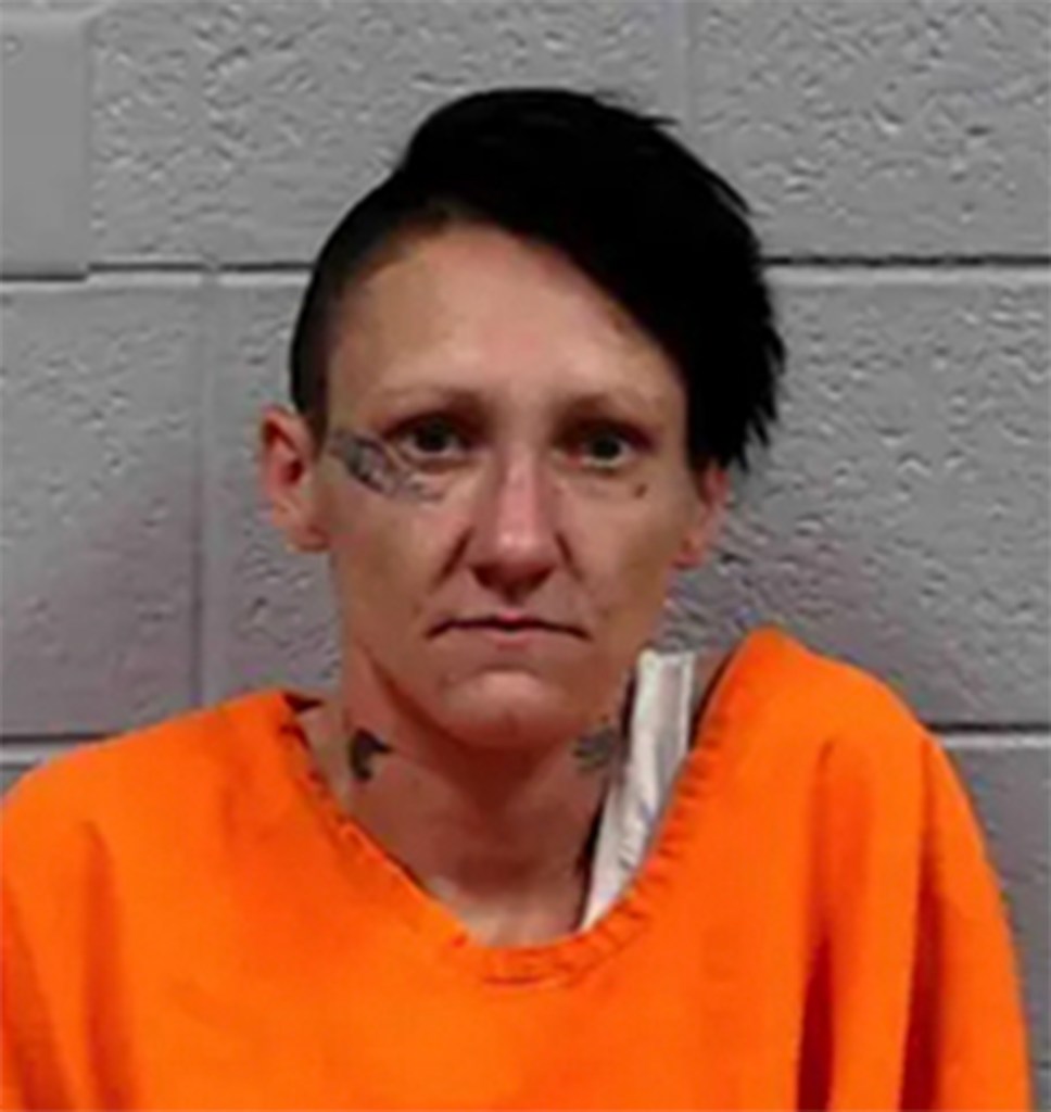 Mugshot of a woman in an orange jumpsuit.