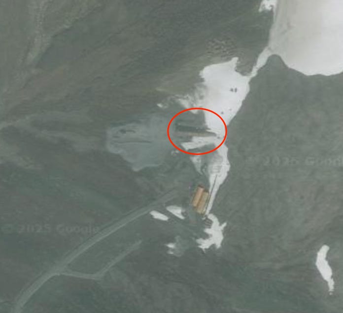 An old satellite photo shows the entrance to a tunnel in the mountains.
