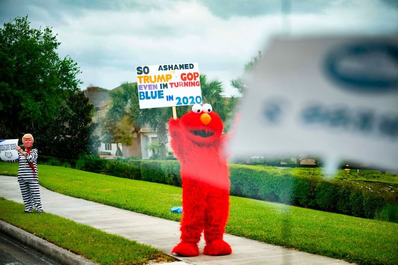 A demonstrator dressed as Sesame Street's Elmo stands on the side of the road as US President Donald Trump's motorcade drives by in Longwood, Florida, on March 9, 2020. (Photo by JIM WATSON / AFP) (Photo by JIM WATSON/AFP via Getty Images)