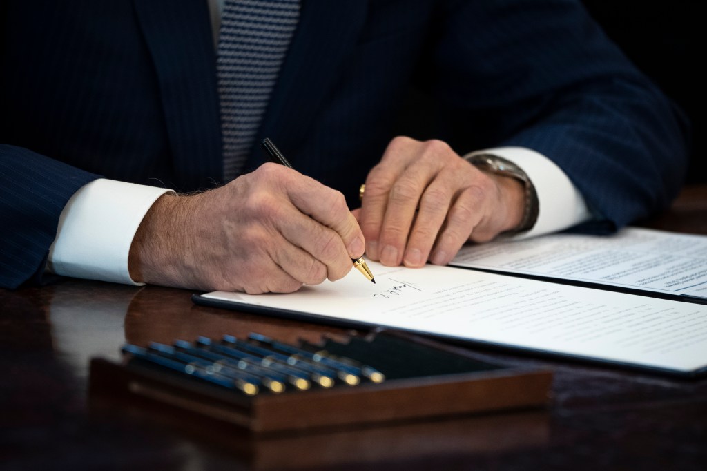 Biden signs an executive order related to government services in the Oval Office of the White House December 13, 2021