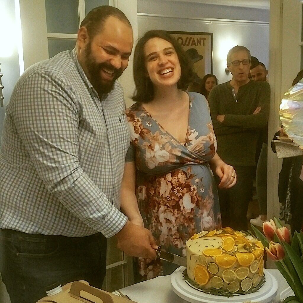 The author and her husband cutting a cake at their baby shower
