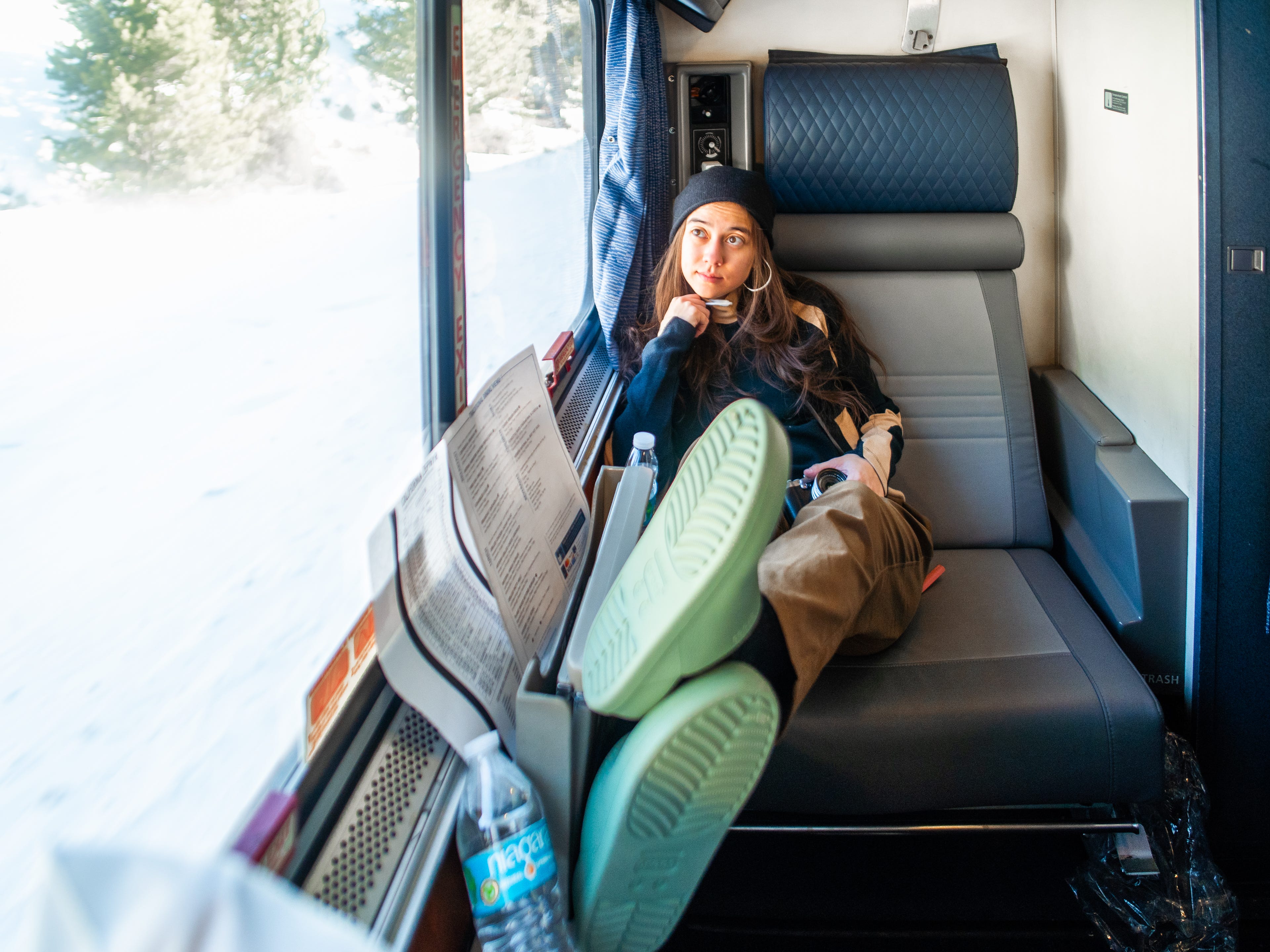 The author lounging with her feet up in an Amtrak train roomette with a window on her right.