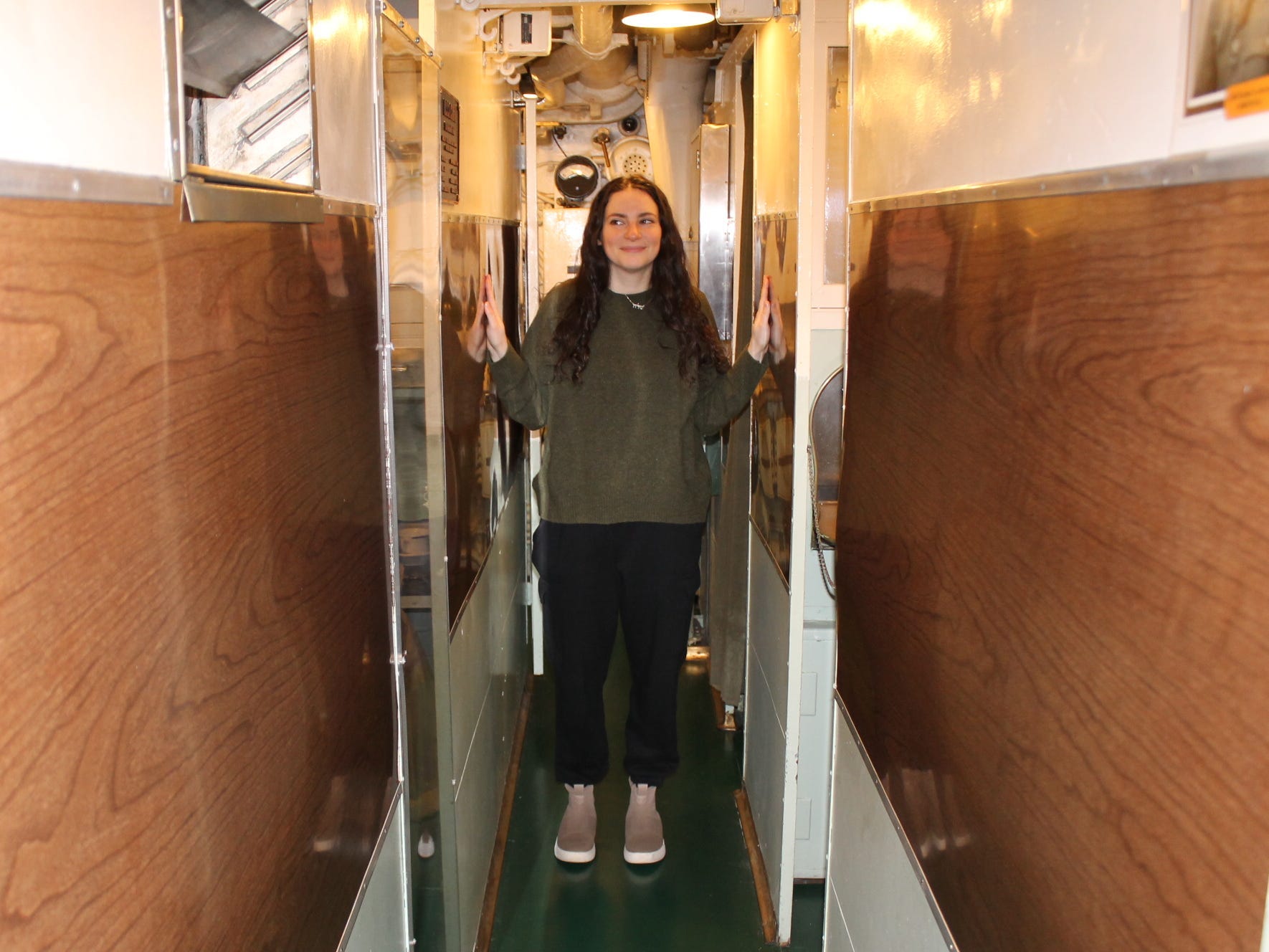 Talia Lakritz stands in a narrow hallway on the USS Cobia.