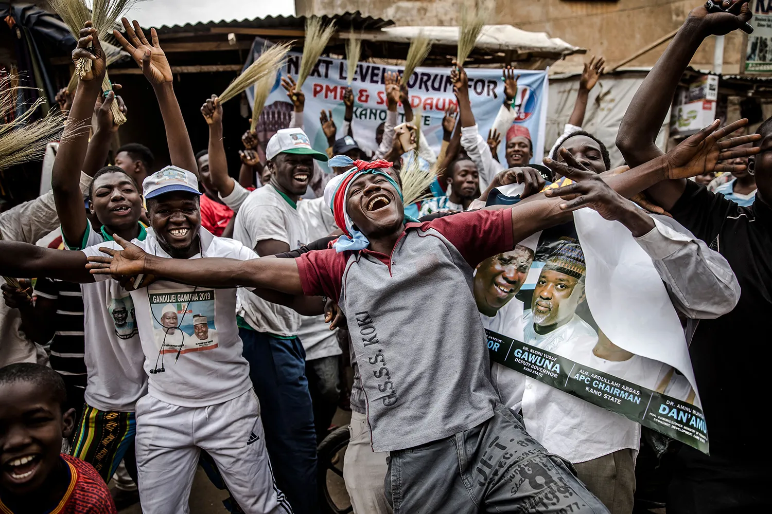 A group of men cheer and raise their hands.
