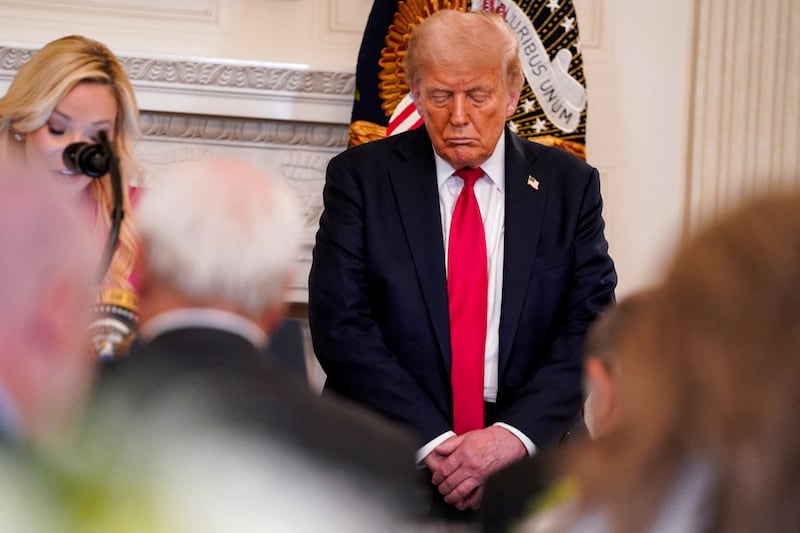President Donald Trump takes part in a prayer led by Paula White, his senior advisor to the White House Faith Office.