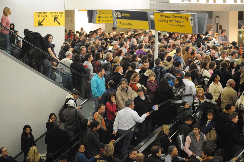Crowded airport escalators with passengers.