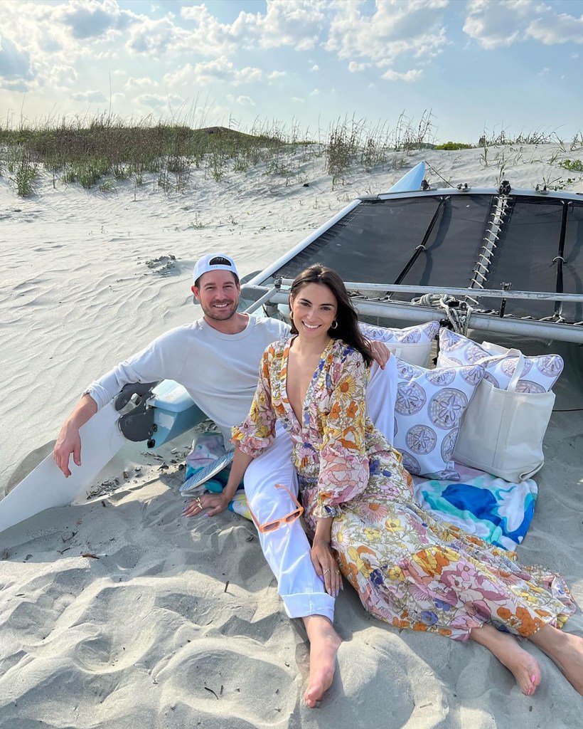 Paige DeSorbo and Craig Conover sitting on the beach.