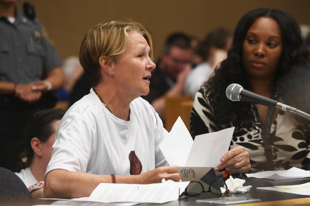 Woman reading victim impact statement at sentencing hearing.