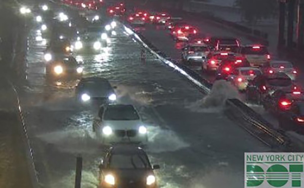 Flooded highway with cars driving through water.