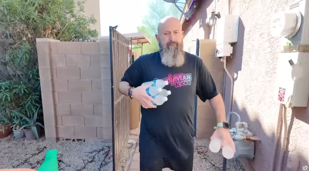 Homeowner David Martin holding water bottles, fined for giving out free water.
