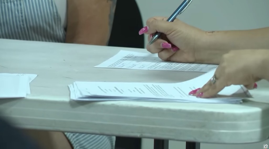 A neighbor filling out a ballot during an election to potentially oust HOA members.