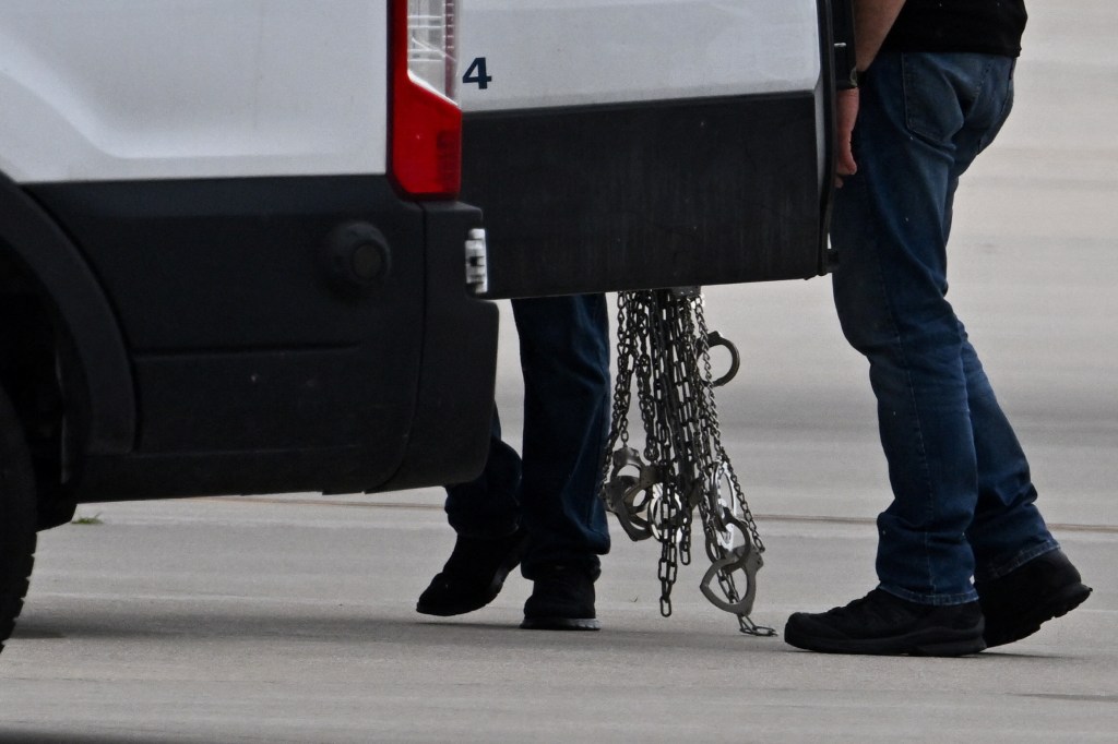 Handcuffs are carried after being removed from detained migrants who boarded a plane after being transferred from an ICE detention facility, at Gary/Chicago International Airport, in Gary, Indiana, U.S., June 20, 2025. 