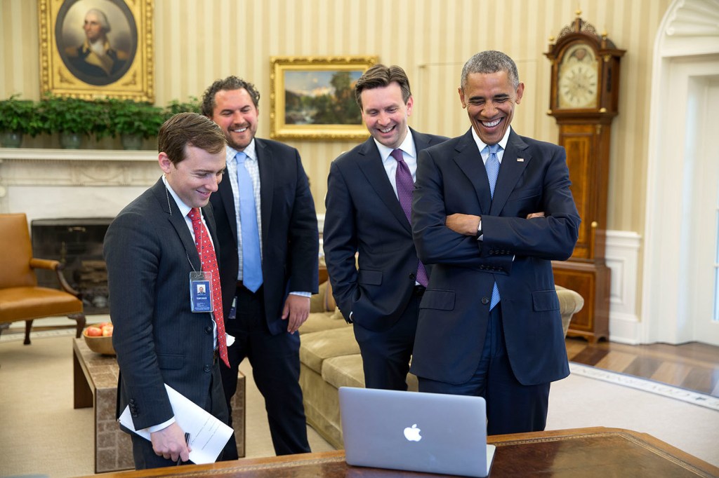 President Obama and his speechwriting team laughing together in the Oval Office.
