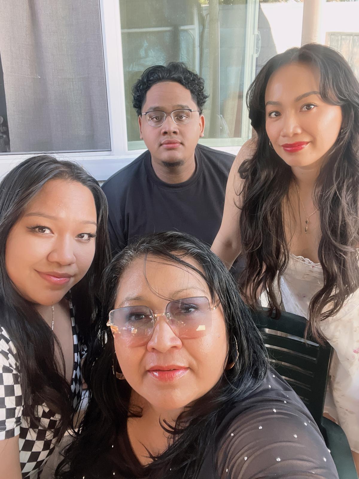 Four people take a selfie together.