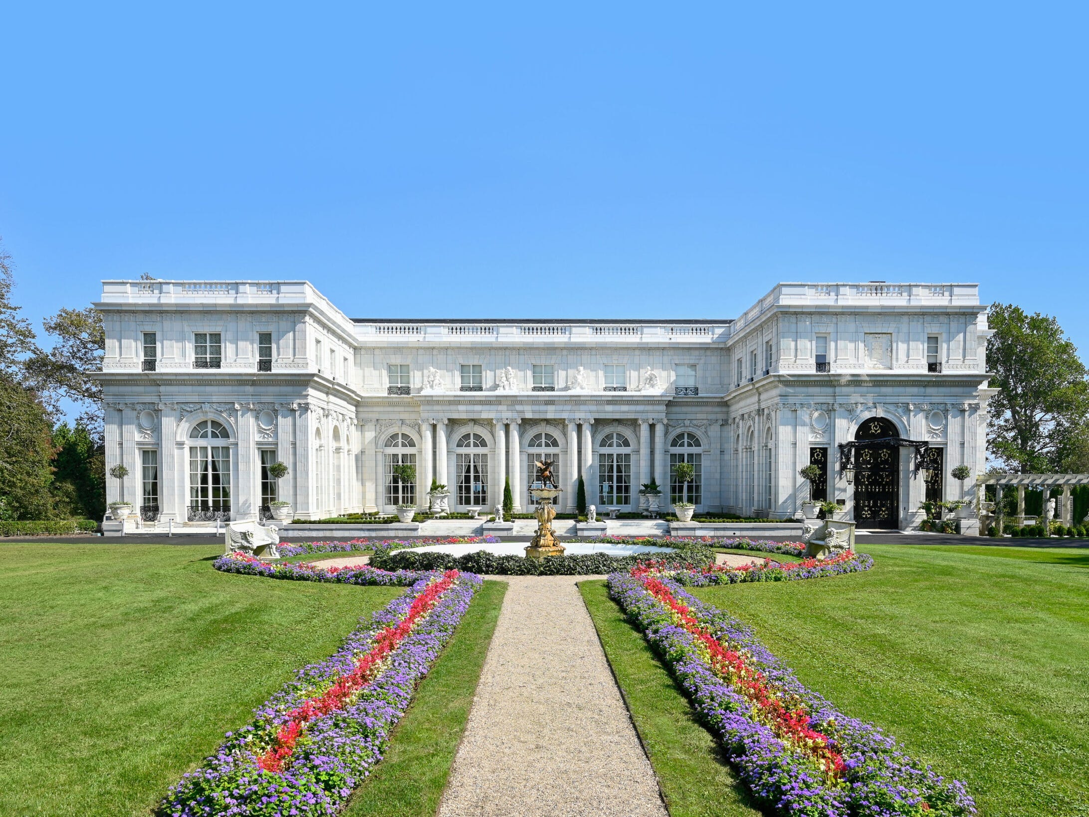 Rosecliff. A giant white mansion with flowers in the front.