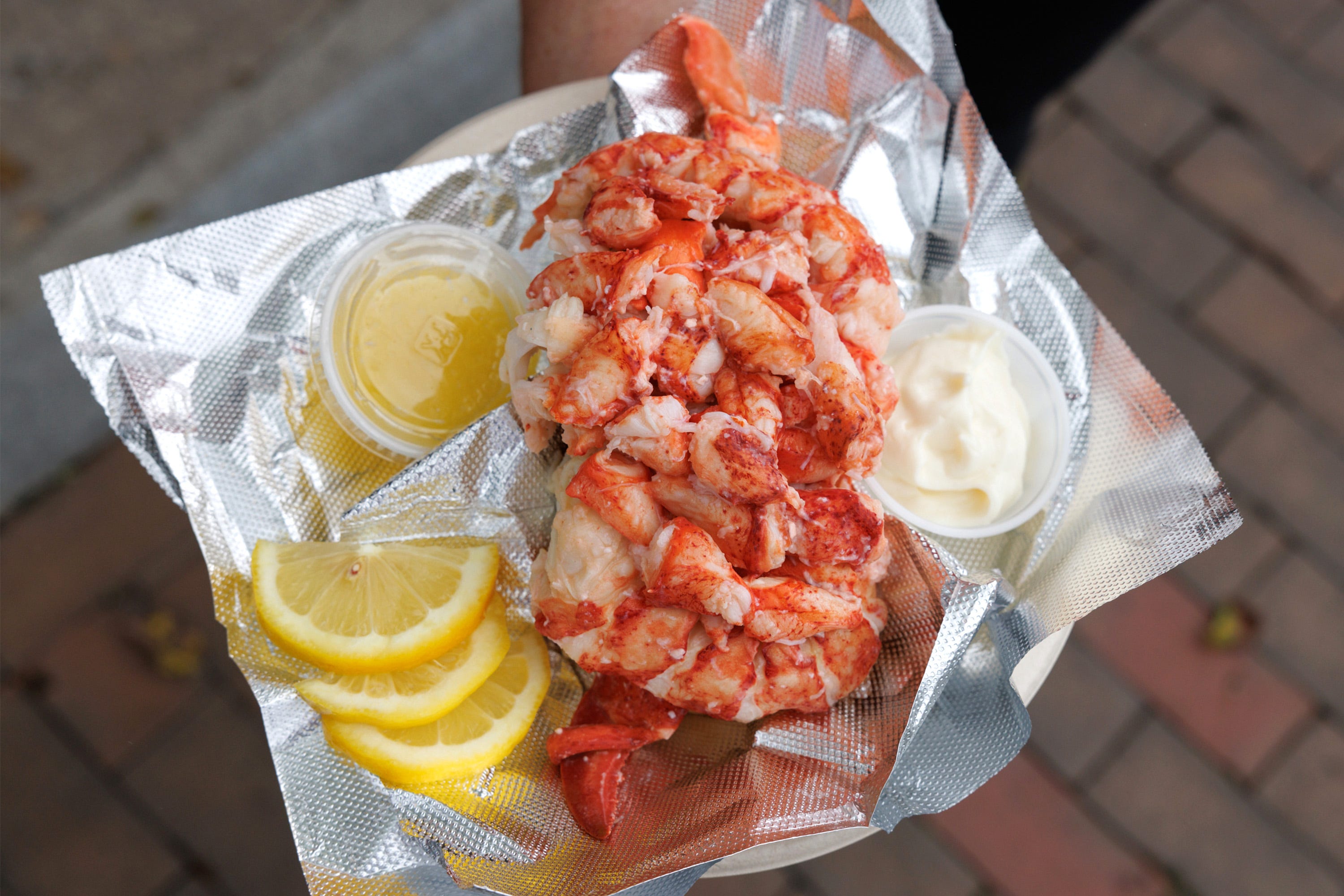 Lobster roll in foil with lemon slices, butter. mayo