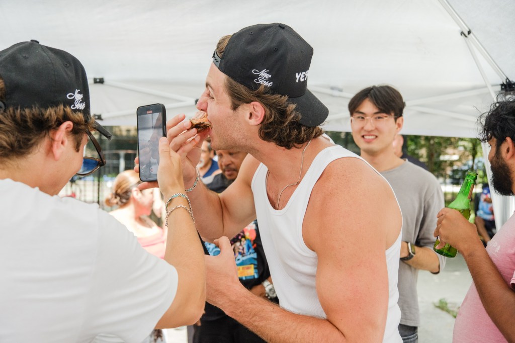 Man eating roast pork while being filmed.
