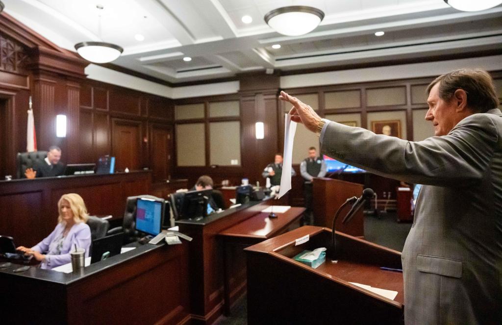 Defense attorney presenting a document in a courtroom.