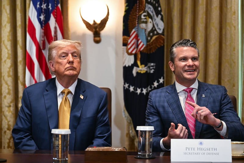 Donald Trump sits next to Secretary of Defense Pete Hegseth