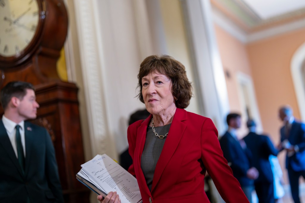 Senator Susan Collins walking in a Capitol building hallway.