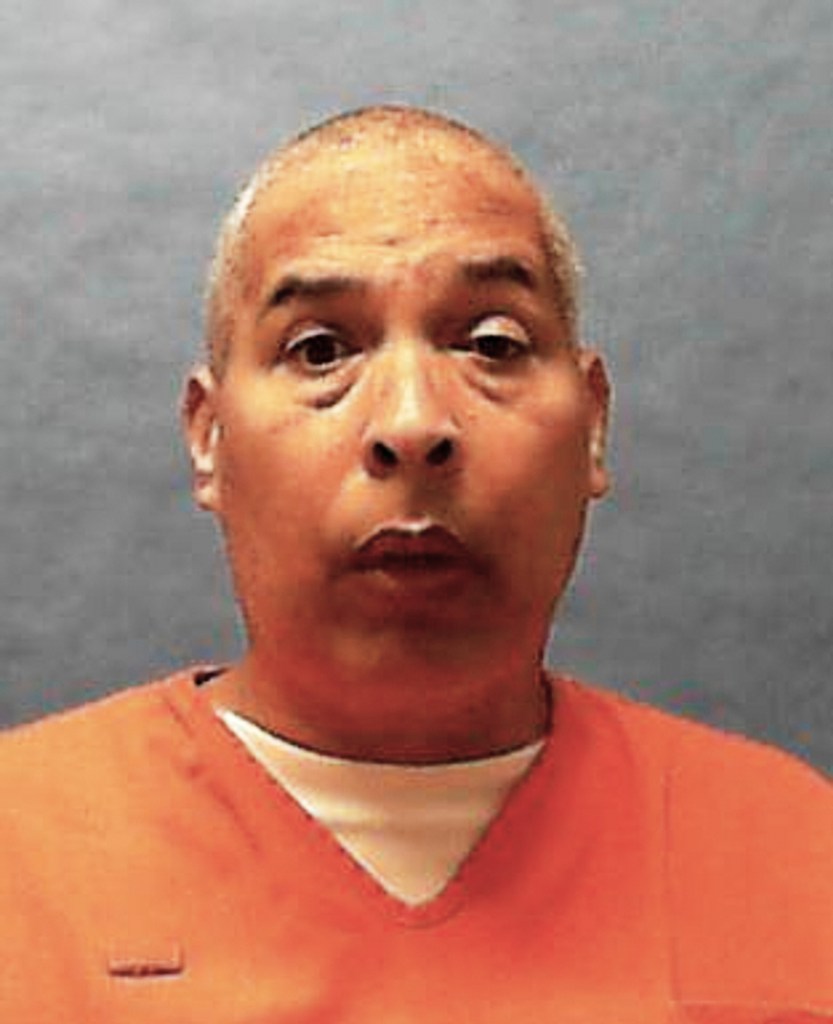Mugshot of a man in an orange jumpsuit.