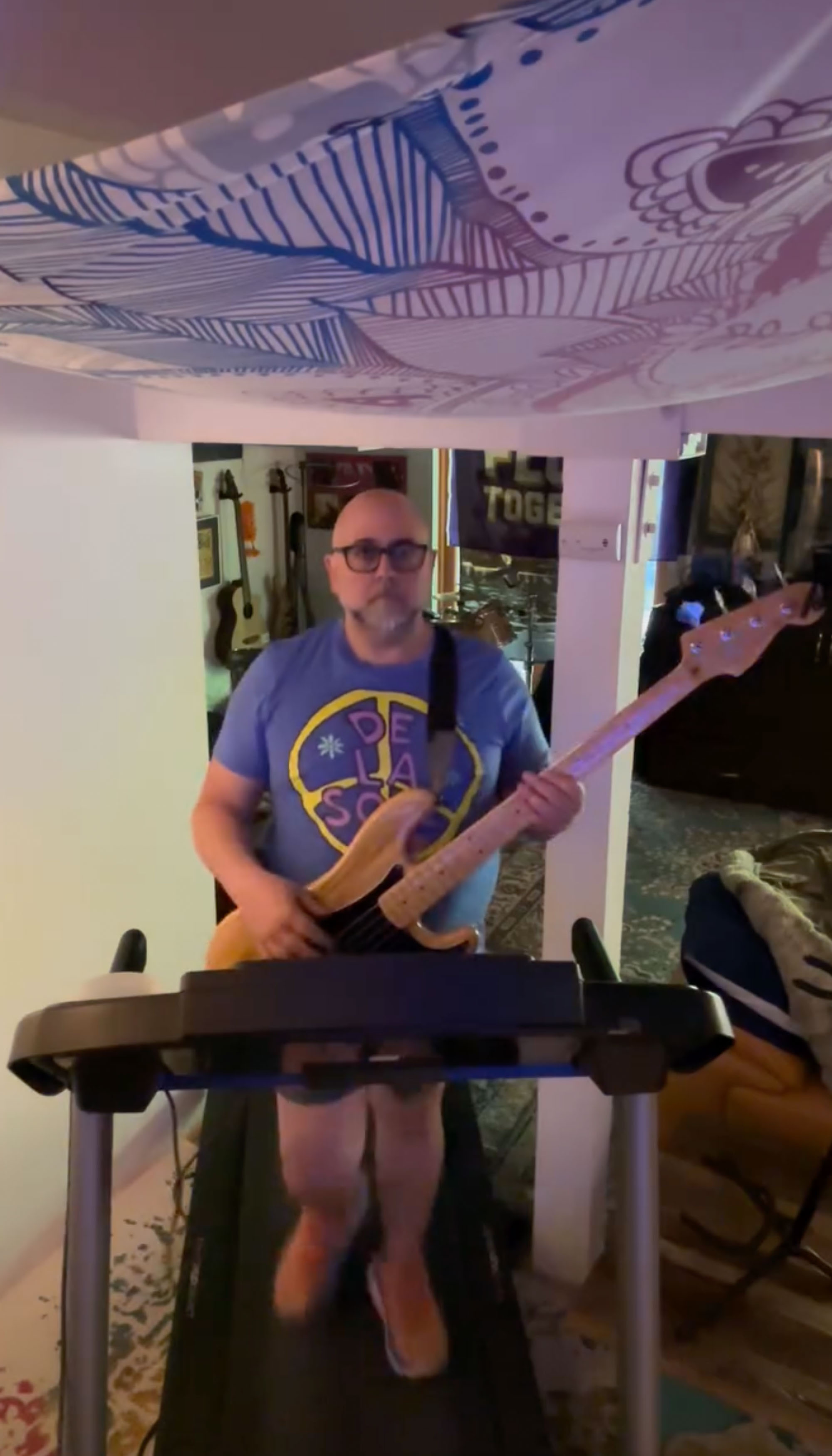 Duff Goldman on a treadmill with a guitar. 