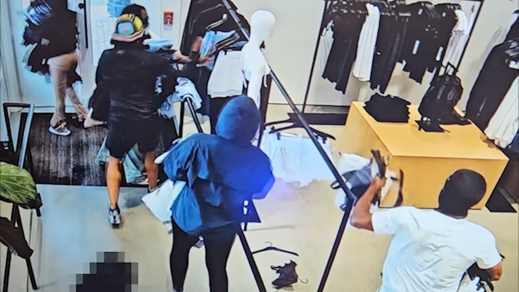 The suspects left the store with armfuls of merchandise before escaping the scene in a silver or gray Ford Edge with covered tags