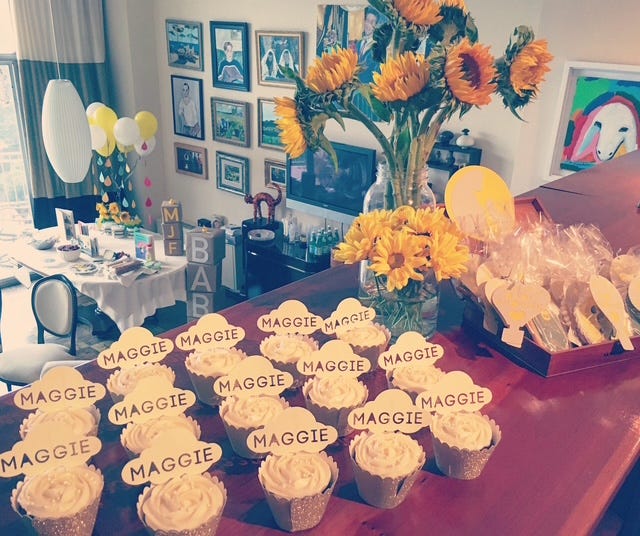 Cupcakes on a table with signs that say "Maggie" on them.