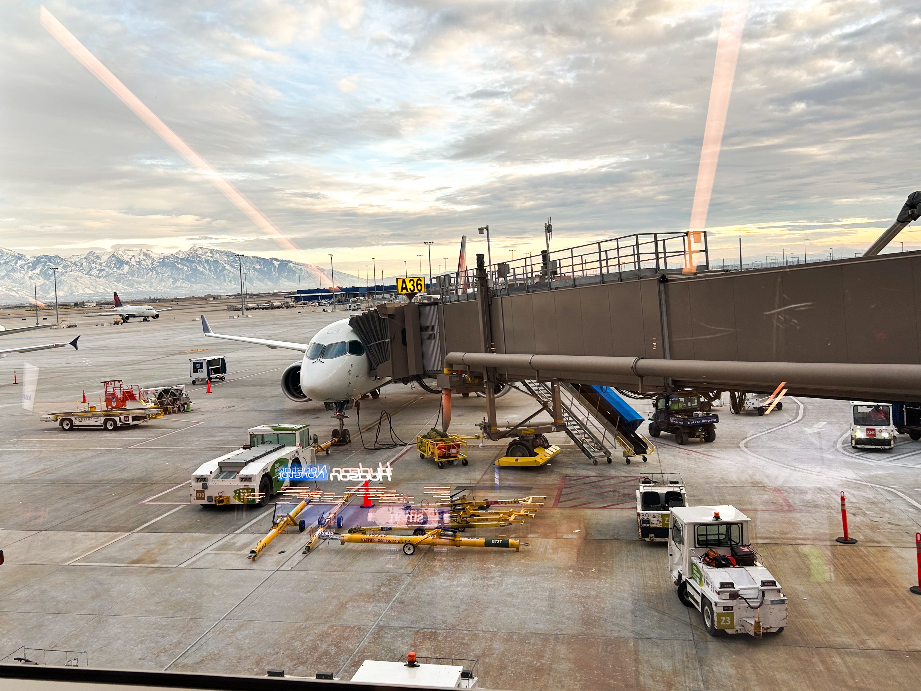 A flight parked on a tarmac with mountains in the background