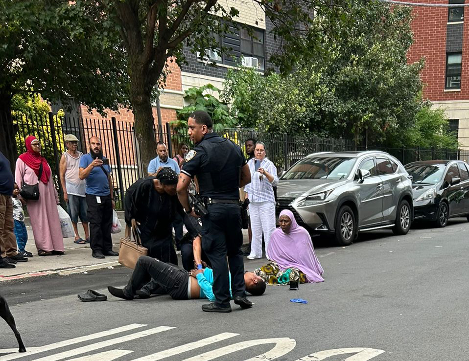 The wounded cabbie's mother rushed to the scene and kneeled by his side in the street. 