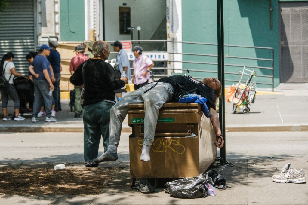 Person sleeping on a public bench.